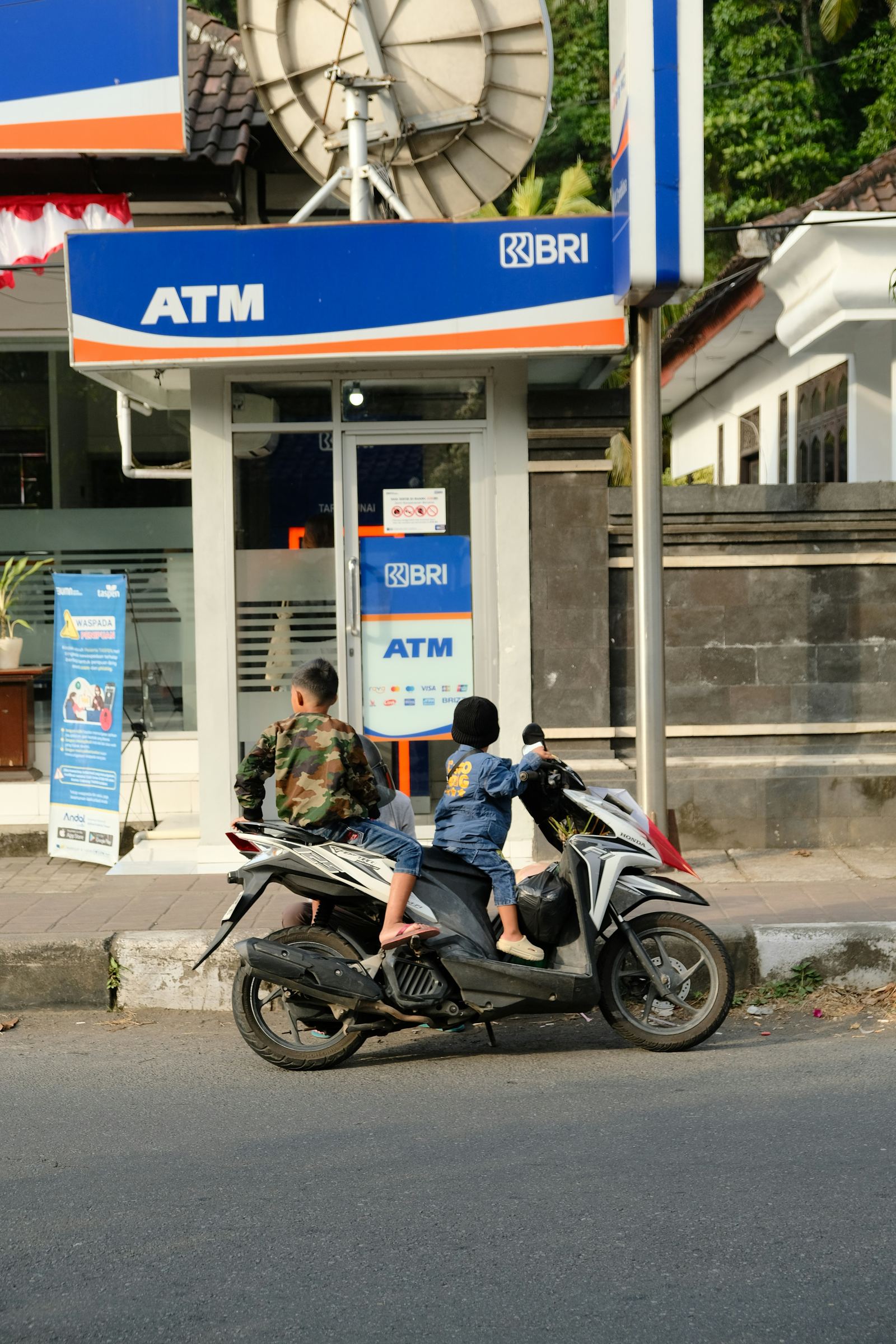 A local BRI ATM in Bali with scooters parked outside