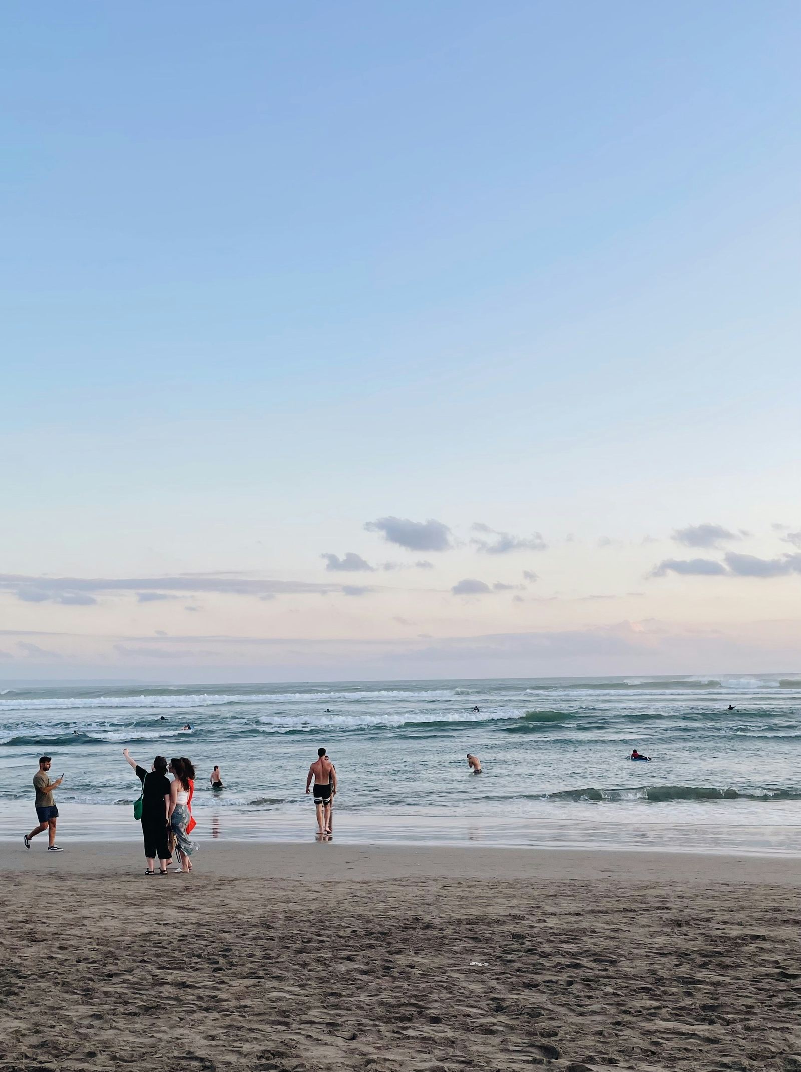 People relaxing on Batu Bolong Beach in Canggu at sunset