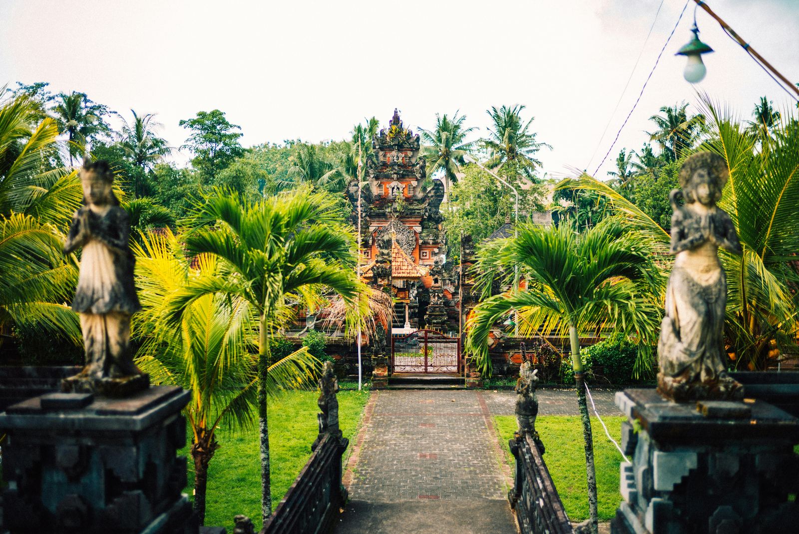 A Balinese temple walkway surrounded by lush greenery in Bali