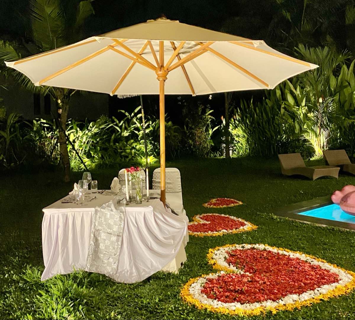 Romantic garden dinner setup with rose petals at Hubuddha Villas